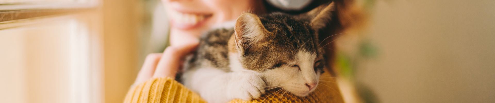 smiling woman hugs cat