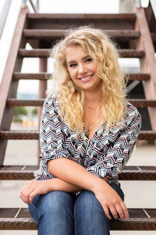 A young female associate sitting on stairs outside the Banfield Pet Hospital